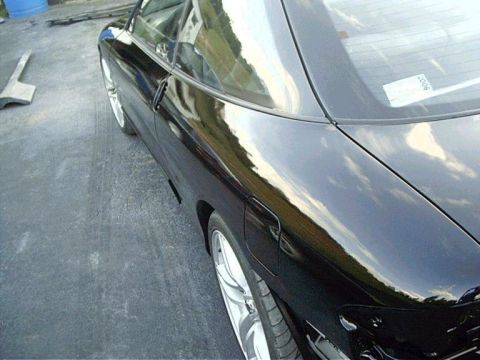 1994 Ford Probe - Side view of a black car, focusing on the rear quarter panel and wheel.
