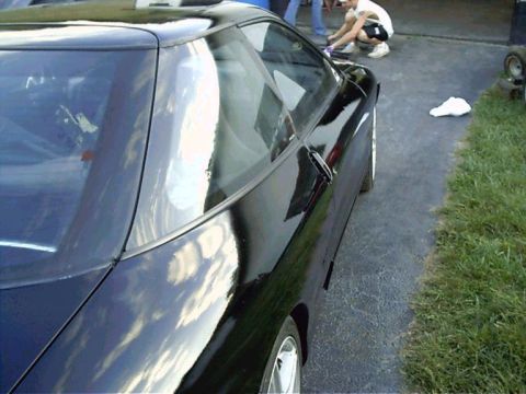 1994 Ford Probe - A black 1994 Ford Probe coupe is viewed from the rear three-quarter angle, parked outdoors.