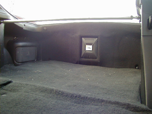 Car's cargo area with a JBL speaker mounted on the side panel