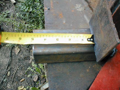1979 Ford Bronco - A metal bar is measured with a tape measure, showing its dimensions.