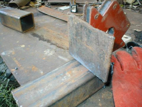1979 Ford Bronco - A close-up view of a metalworking setup, a welding magnet, protective gloves, and various steel components on a workbench.