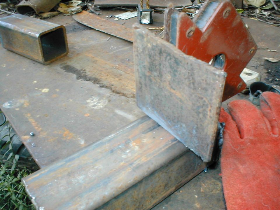 Metalworking scene with welding magnet, gloves, and steel pieces