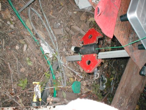 1979 Ford Bronco - A close-up view of welding magnets and a green hose lying on the ground amidst debris.