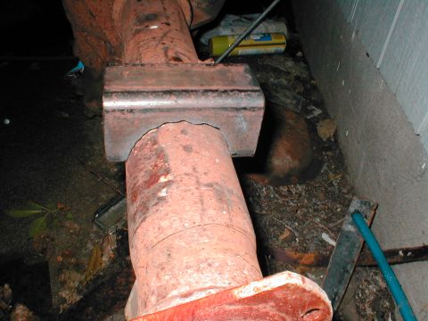 1979 Ford Bronco - Close-up of a rusted metal pipe section with a bracket, possibly part of an exhaust system.