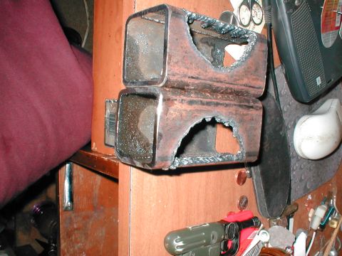 1979 Ford Bronco - Welded metal brackets with rough cutouts, attached to a wooden structure.