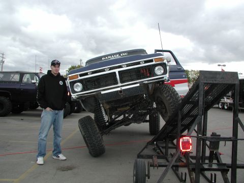 1977 Ford F-150 - A modified 1977 Ford F-150 is positioned on a ramp, with a person standing nearby and another vehicle in the background.
