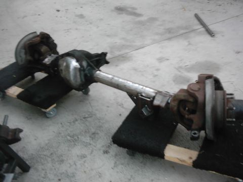 1978 Ford Bronco - A rear axle assembly is shown on a workshop floor, resting on blocks and casters.