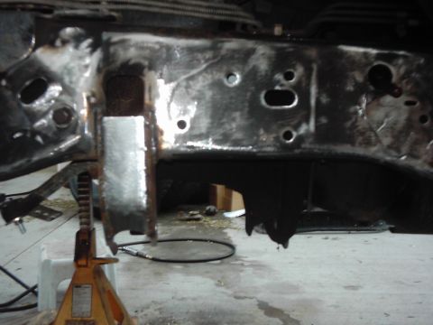 1978 Ford Bronco - Vehicle frame undergoing repair work, with a jack stand providing support.