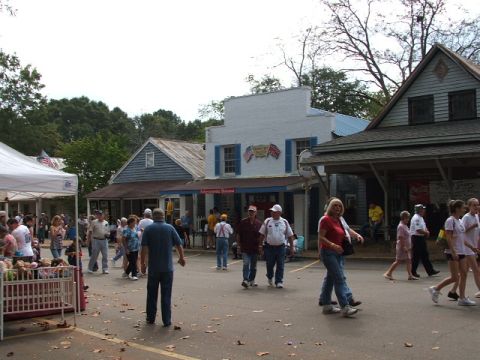 1966 Ford Ranchero - A crowd mills about in front of shops at a daytime outdoor gathering.