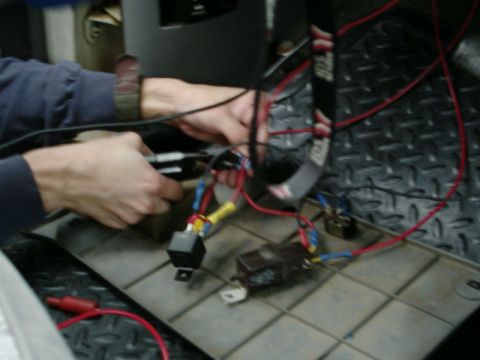 1988 Ford Bronco - Two hands crimp red and blue insulated spade terminals onto a horn wiring harness laid out on a black diamond-plate work surface. A black f…