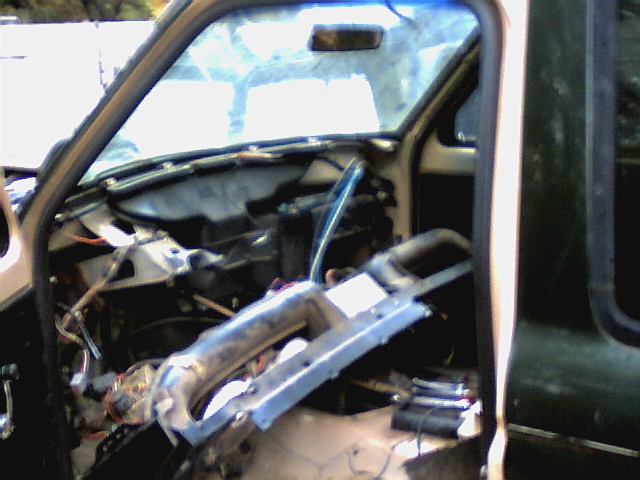 Stripped truck cab interior with dash removed, exposing wiring and steering column