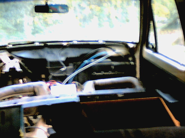 Interior view of a car with dashboard removed, showing wiring and components