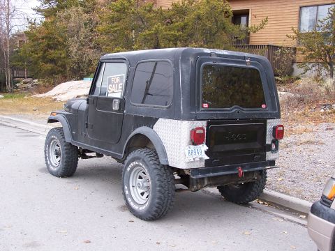 1983 Jeep CJ7 - This Jeep CJ is parked on the side of the road with a 'For Sale' sign visible in the driver's side window.
