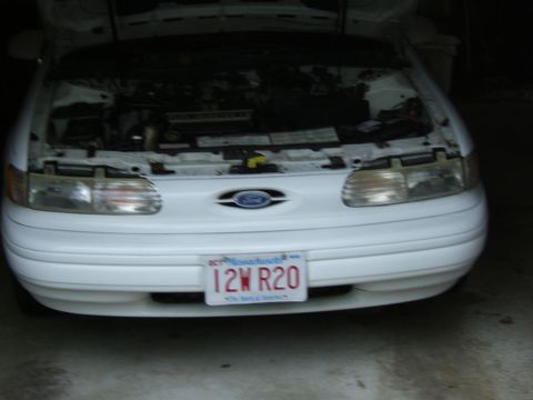 1998 Ford Taurus - Front view of a 1998 Ford Taurus with its hood open, revealing the engine compartment.