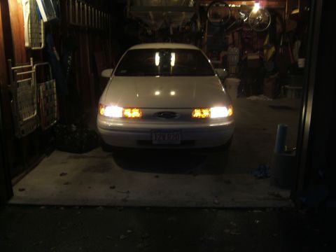 1998 Ford Taurus - Front view of a 1998 Ford Taurus with its lights illuminated inside a garage.
