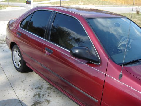 1998 Nissan Sentra - This red sedan is parked on a concrete driveway with some grass clippings visible.