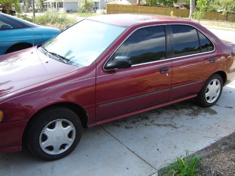 1998 Nissan Sentra - A maroon sedan is parked on a concrete driveway next to a blue car.