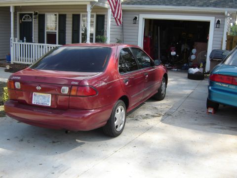 1998 Nissan Sentra - A red 1998 Nissan Sentra is parked in a driveway with a garage and house visible.