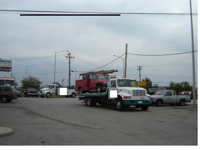 Tow truck front view carrying red pickup truck