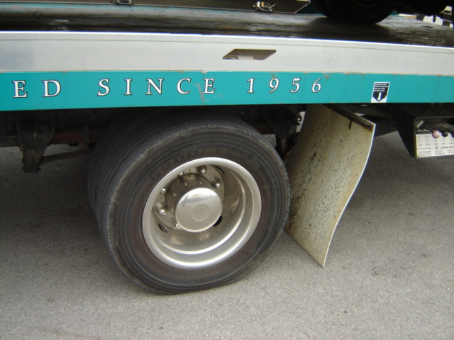 Tow truck side with a teal stripe reading "ED SINCE 1956" and a large tire