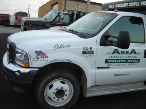 1992 Ford Bronco - White Ford F-550 truck with company branding and a 9/11 memorial sticker is parked near other trucks.