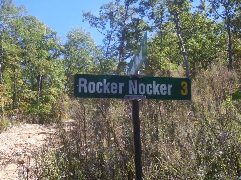 1986 Ford Bronco - A road sign indicates 'Rocker Nocker 3' amidst trees and dry vegetation.