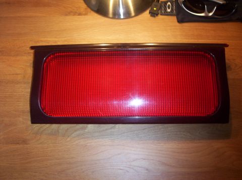 1994 Ford Probe - A single red taillight assembly is shown against a wooden background, with a website watermark at the bottom right.
