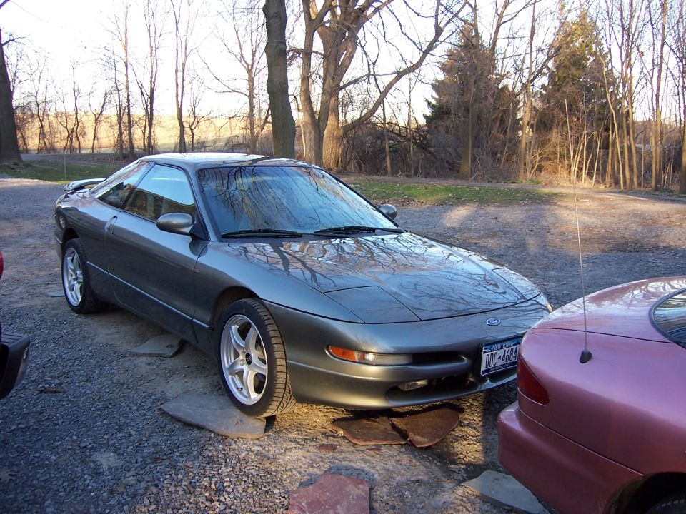 Gray 1996 Ford Probe parked outside next to a pink car