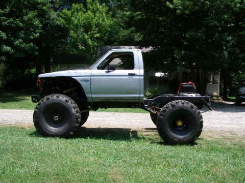 1985 Ford Bronco - This heavily modified truck features massive tires and a custom chassis, deviating significantly from a stock 1985 Ford Bronco.