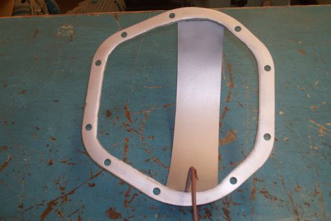 1983 Ford Bronco - A differential cover gasket is shown on a workbench.