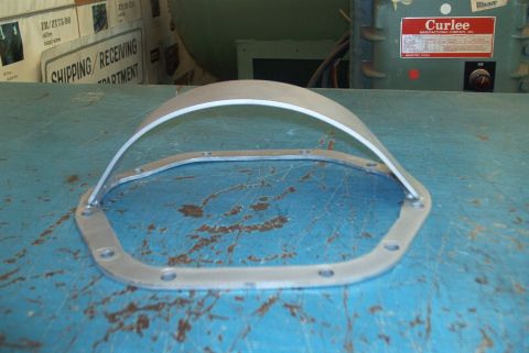 1983 Ford Bronco - A metal differential cover and gasket are shown on a workbench, with shipping labels and industrial equipment visible.
