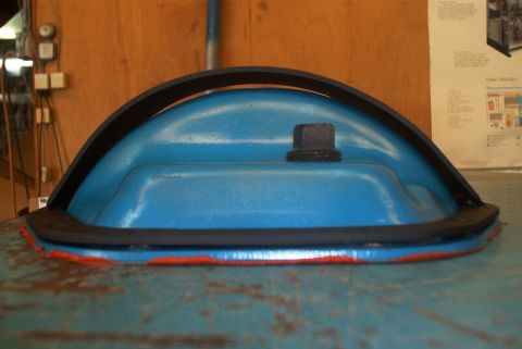 1983 Ford Bronco - Close-up of a blue plastic component with a black seal and orange trim.