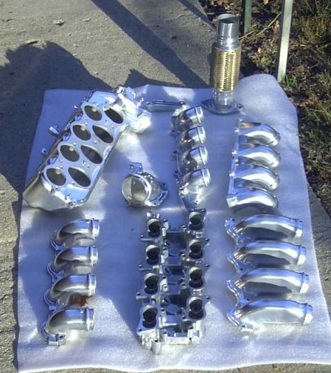 1997 Ford Taurus - Polished intake manifold parts are arranged on a white cloth outdoors.