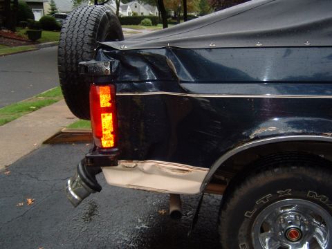 1993 Ford Bronco - Rear view of a dark blue 1993 Ford Bronco showing damage to the quarter panel and bumper area.
