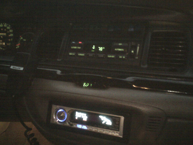 Dashboard interior with aftermarket stereo and digital clock showing 62