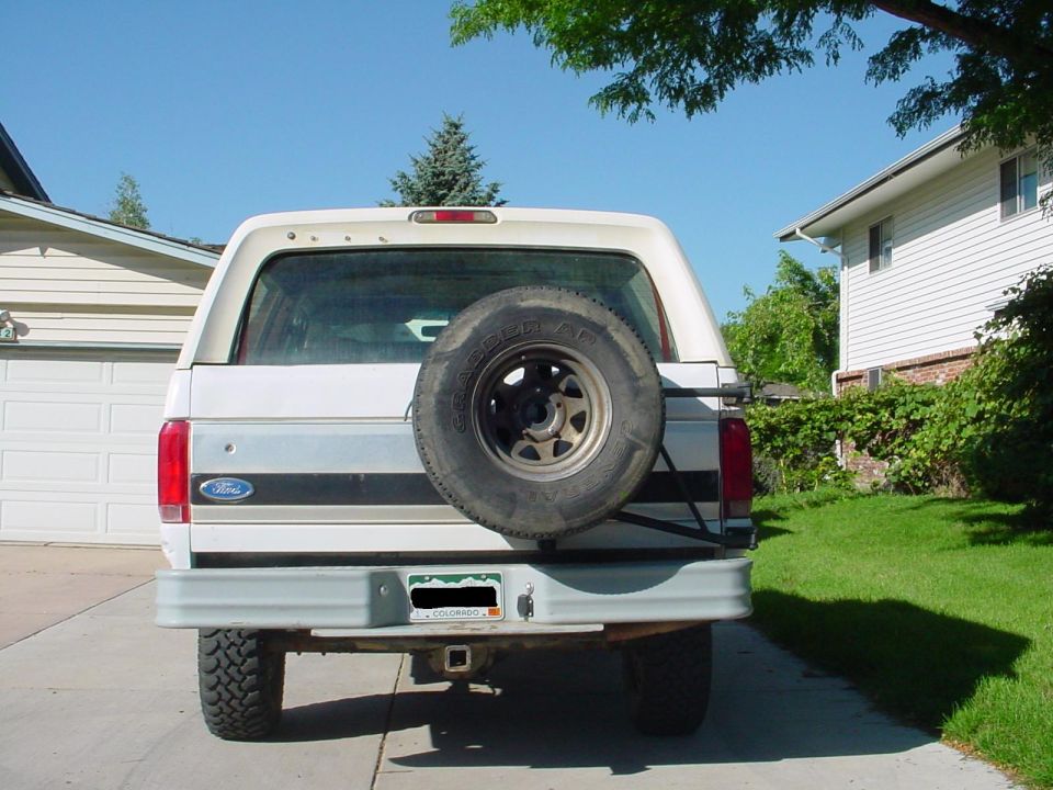 Rear of white Ford Bronco with tailgate-mounted spare tire and Colorado plate