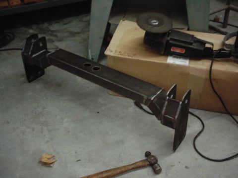 1978 Ford Bronco - A custom metal fabrication part is shown on a concrete floor, with tools and a box in the background.