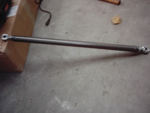 1978 Ford Bronco - Close-up of a single automotive part, likely a tie rod end, on a concrete floor.