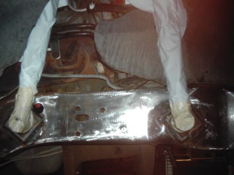 1978 Ford Bronco - The underside of a vehicle's frame is shown, with parts covered in white material.