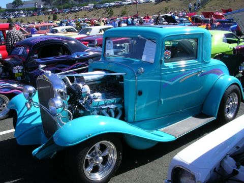 1996 Ford Probe - A teal hot rod coupe with a custom paint job and exposed engine is parked at an outdoor car show.