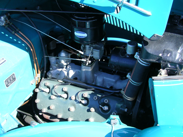 close-up of a car engine with blue paint on the fenders and hood