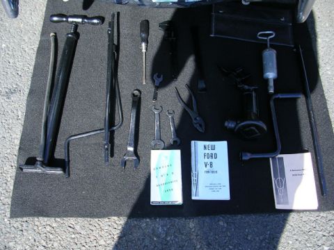 1996 Ford Probe - A selection of vintage Ford V-8 tools and accessory manuals from 1936 are laid out on a dark mat.