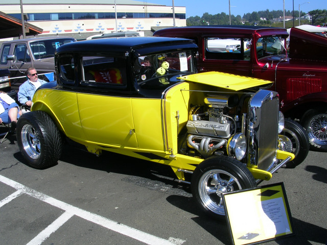 Yellow and black hot rod, front 3/4 view, exposed Chevrolet engine