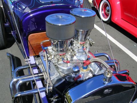 1996 Ford Probe - A highly customized engine with dual carburetors and polished chrome headers is visible in this hot rod, with a red car in the background.
