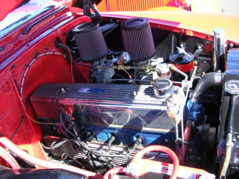 1996 Ford Probe - Close-up view of a car's engine bay, chrome valve covers and dual carburetors.