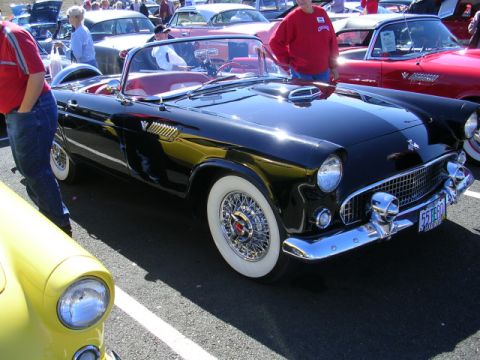 1996 Ford Probe - A black 1955 Ford Thunderbird convertible is parked at an outdoor car show with other vehicles.