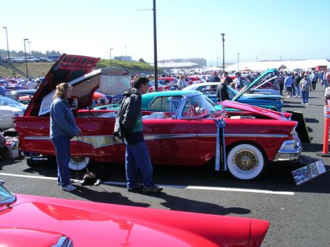 1996 Ford Probe - Classic car show features a red vintage automobile with its hood and trunk open for display.