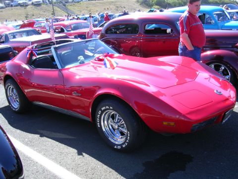 1996 Ford Probe - A red convertible sports car, likely a Chevrolet Corvette from the mid-1970s, is displayed at a car show.