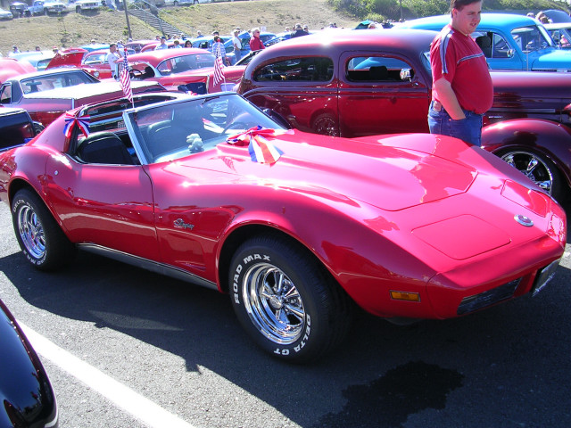 Red convertible sports car with chrome wheels and American flag decorations