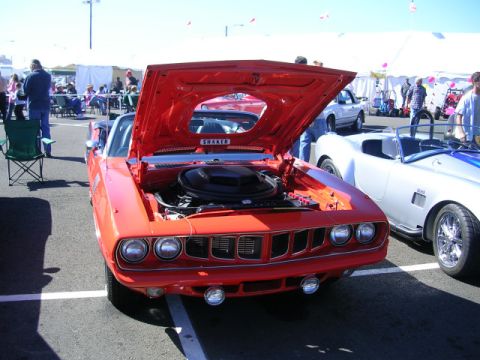 1996 Ford Probe - Orange 1970 Plymouth Barracuda on display at a car show, with its hood open to reveal the engine.